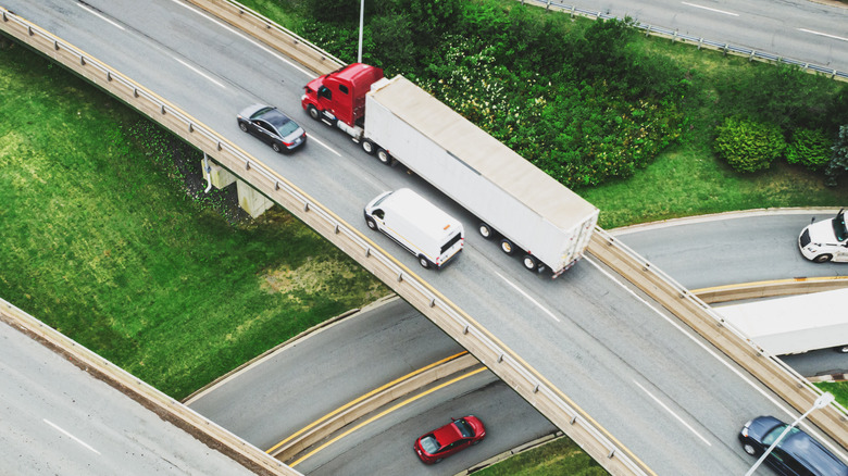 Aerial view of semi truck on a road with cars on the left