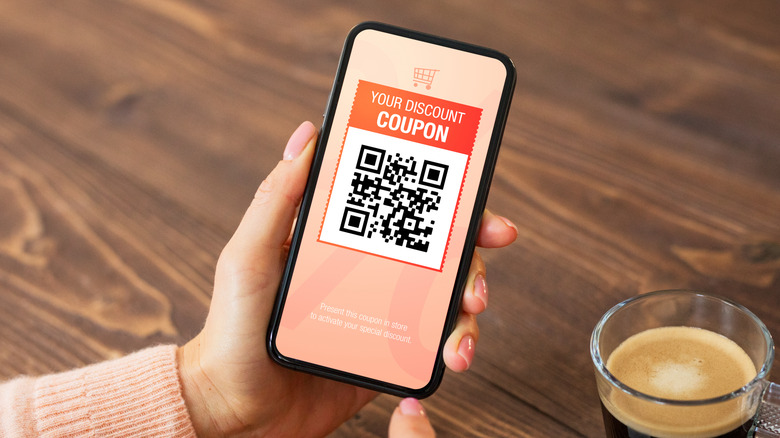 Woman viewing discount coupon QR code on her phone