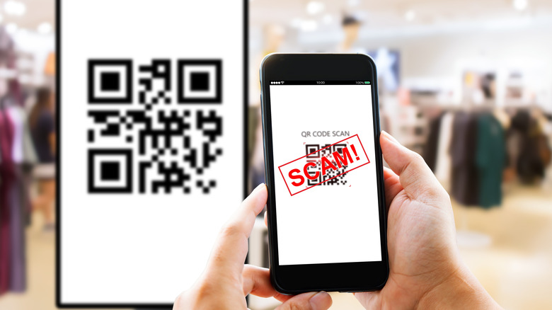 Man's hands using a phone to scan a fake QR code