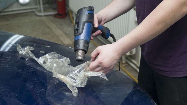 Removing the old protective film from the hood of the car