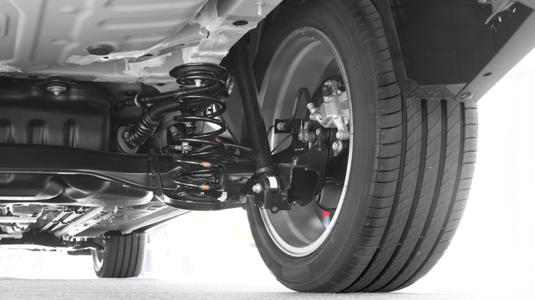 Car undercarriage showing the suspension, tires, and driveshaft