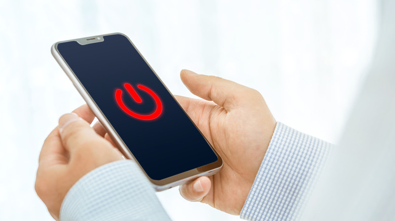 Power icon on a man's smartphone.