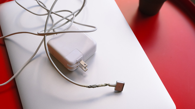 Cargador de laptop con cable retorcido cerca del puerto