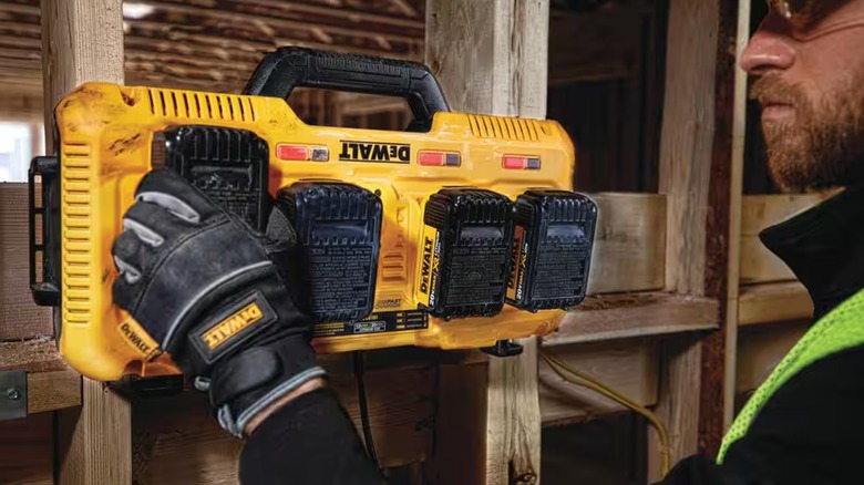 A worker places batteries on the DeWalt 4-port charger
