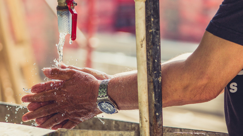 Person washing their hands at construction site