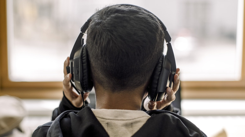 A person holding their headphones.