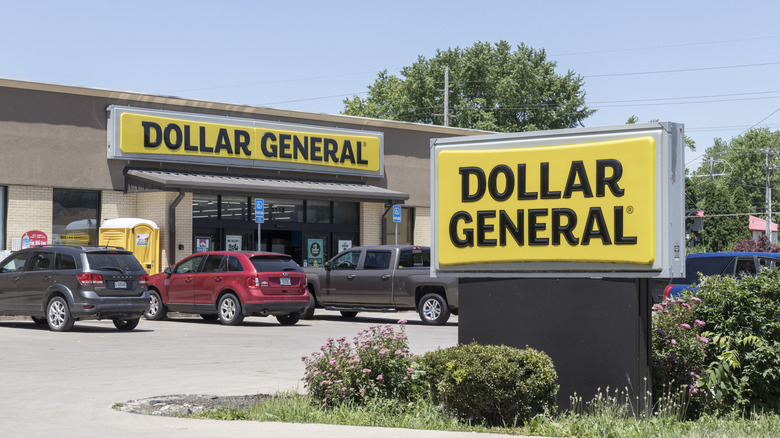 Cars parked in front of a store fronting Dollar General signs