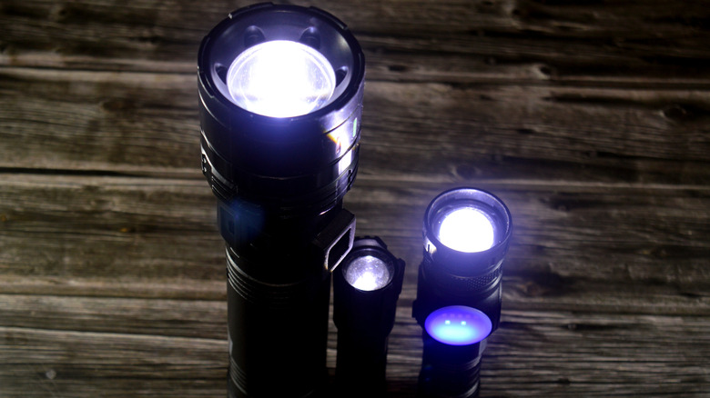 A handful of high-lumen tactical LED flashlights standing on end.