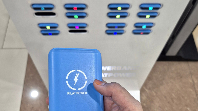 Close-up view of a rented power bank in front of a power bank rental machine