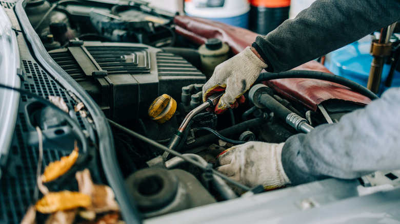 Person using tools to modify engine