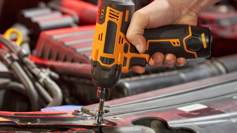 A person using an impact driver.