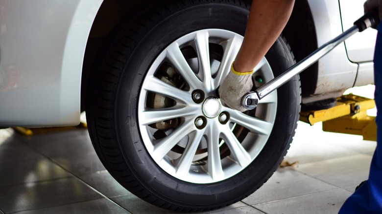 A mechanic torquing the lug nuts on a car.