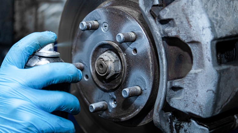 Applying lubricant to wheel studs.
