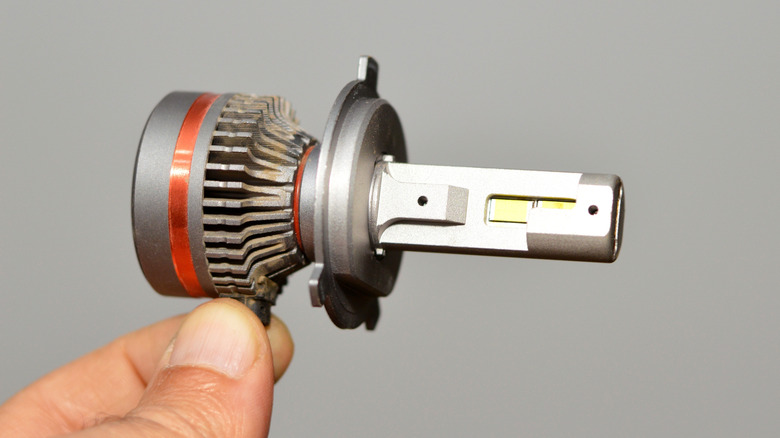Person holding an aftermnarket LED headlight bulb