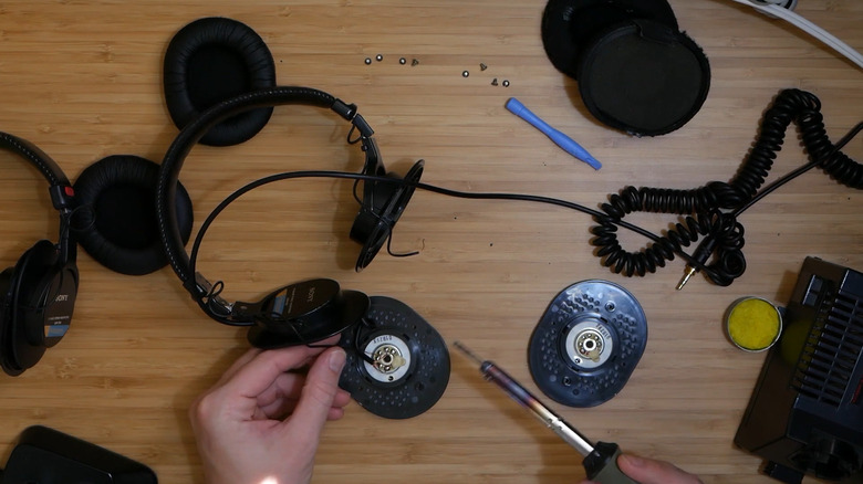 Sony headphones being repaired on a wooden table