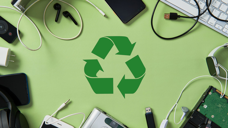 Recycling icon surrounded by old electronics