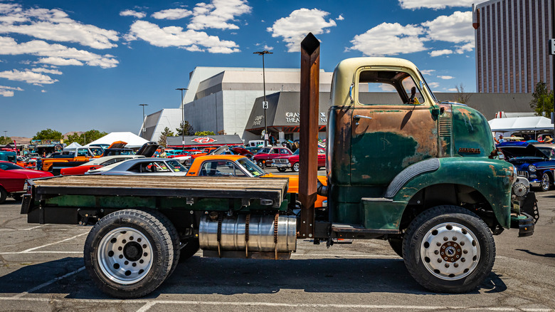 Side view of a vintage semi-truck, converted to a flat-bed, at a car show.