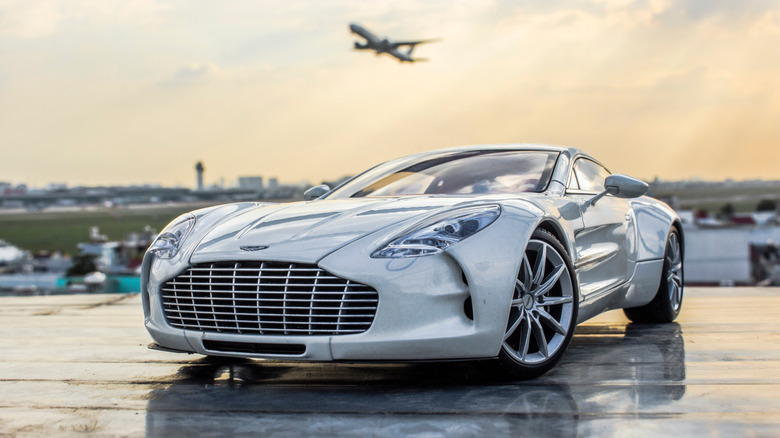 Aston Martin One-77 in front of airplane