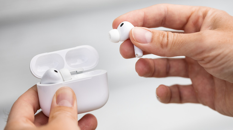 Person taking AirPods out of the charging case