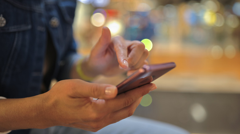 woman tapping on phone screen