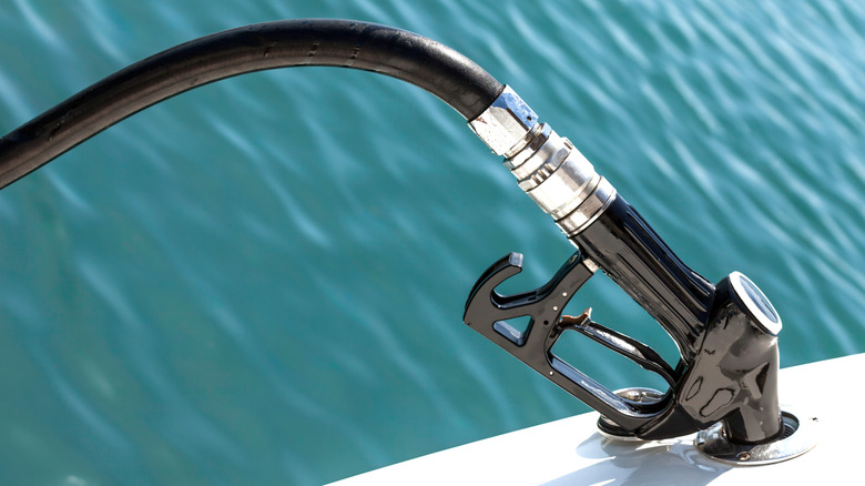 Close-up of gas nozzle inserted into a boat to fill it with gas