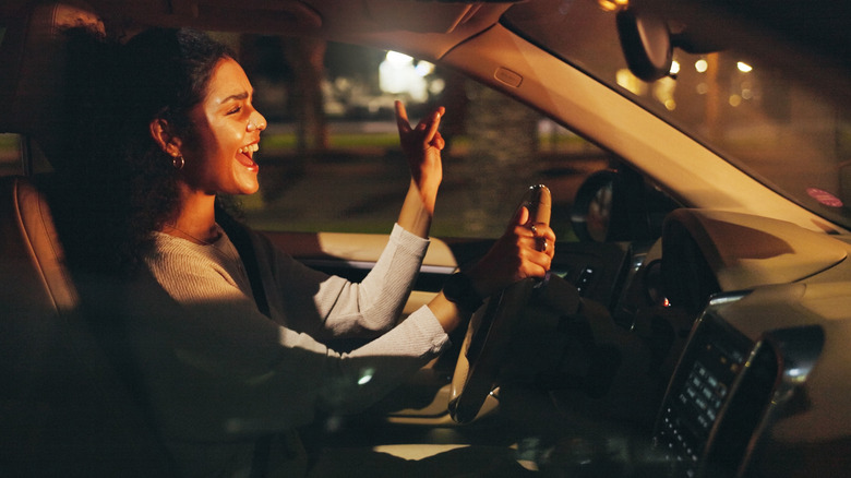 Someone singing and driving at night.