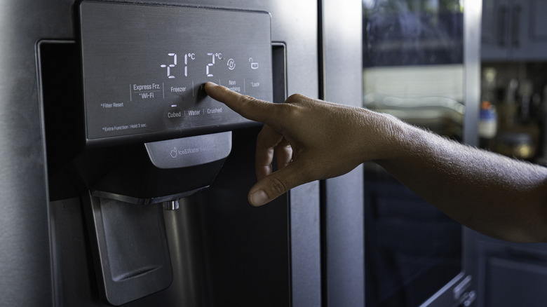 A closeup of a modern refrigerator water and ice dispenser