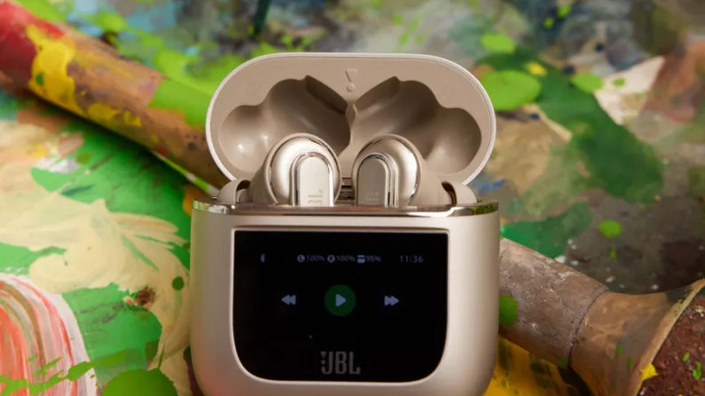 JBL in-ear headphones on table with painting supplies