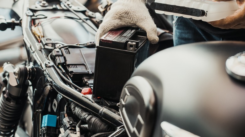 A man holding a motorcycle battery