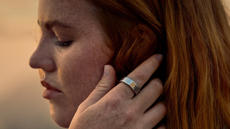 A girl wearing an Oura Ring 3 on her index finger.