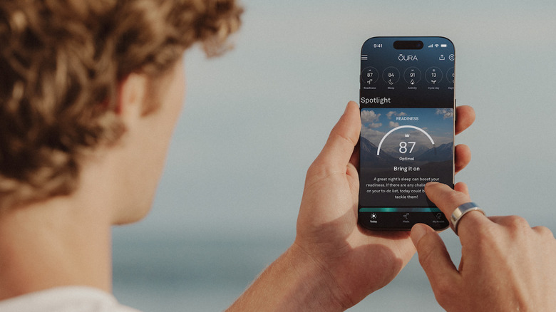 A boy using the Oura app on his smartphone.