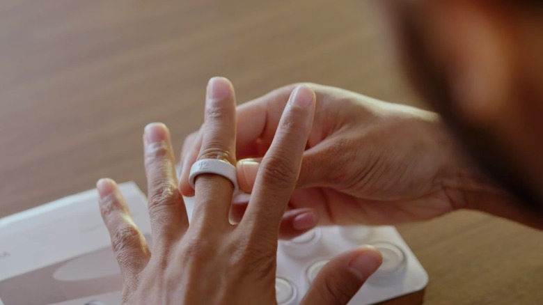A man wearing an Oura Ring 4 on his middle finger.