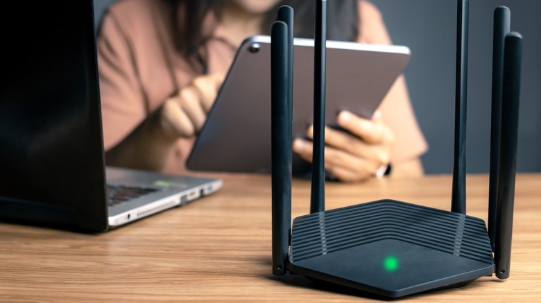 woman using iPad next to Wi-Fi router