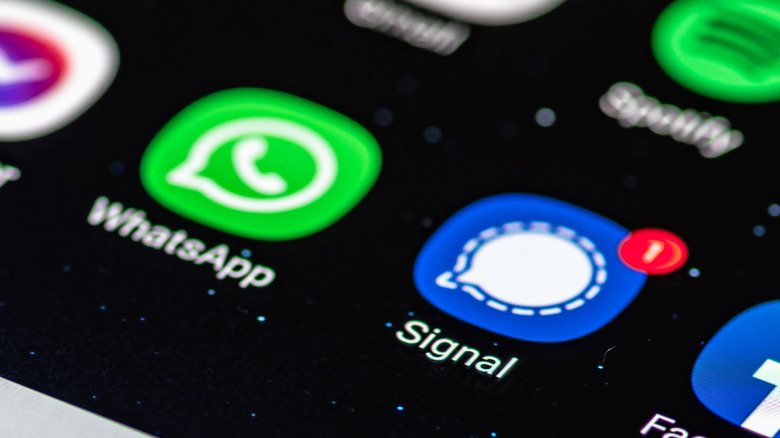 WhatsApp and Signal icons on a smartphone display.