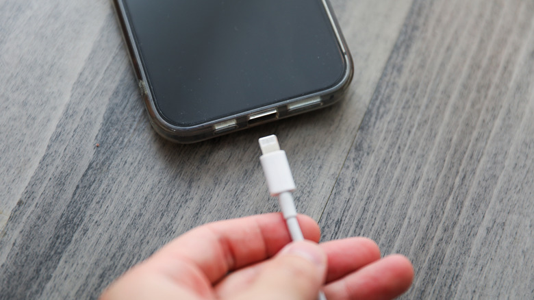 iPhone charging cable next to the phone