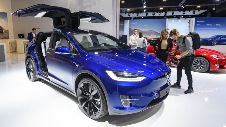 Blue Tesla Model X with doors open at auto show