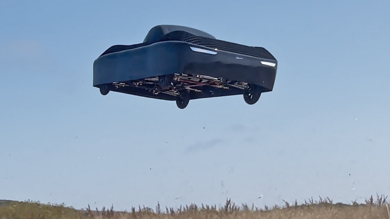 Low-angle shot of a black Alef Model A hovering against a clear sky.