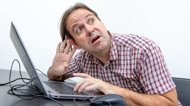 man troubleshooting audio on laptop