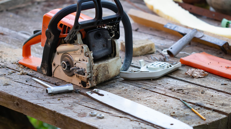 Disassembled chainsaw on a wooden table