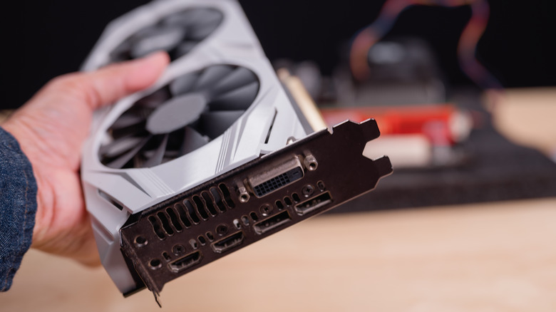 A person holding a graphics card.