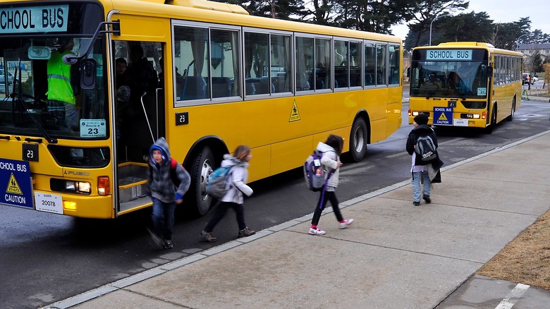 Students walking away from yellow school buses toward school
