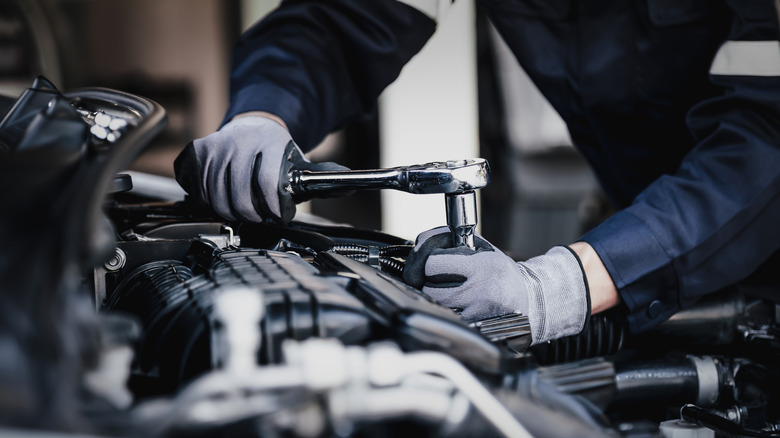 mechanic making repairs in a car