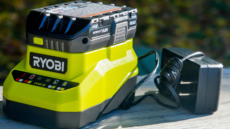 Ryobi battery charger with battery on table outside