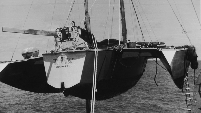 Teignmouth Electron tailing trimaran hoisted onto a ship