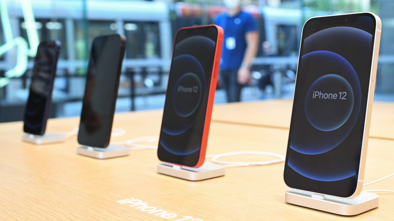 Several iPhone 12 models in a store.