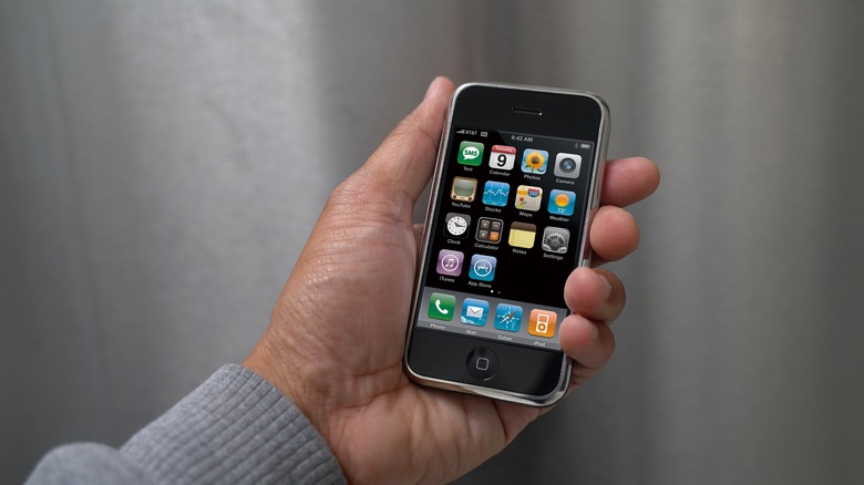 Person holding first generation iPhone