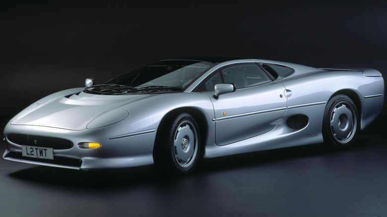 Silver Jaguar XJ220 parked in black room