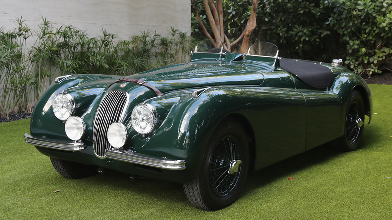 Green Jaguar XK120 parked on grass