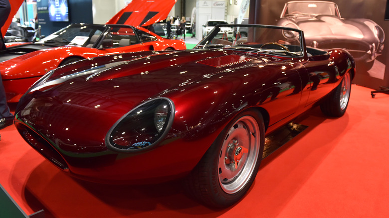 Maroon Low Drag Jaguar E-Type parked on red carpet