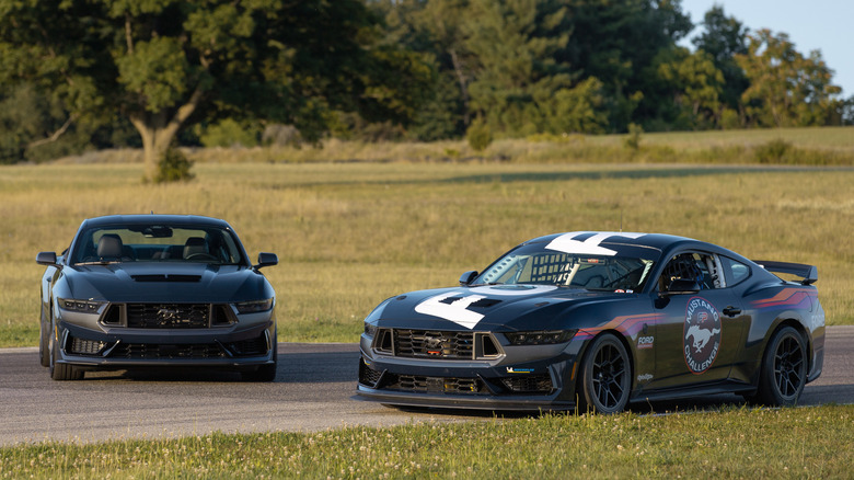 Two Ford Mustang Dark Horse Rs parked on track